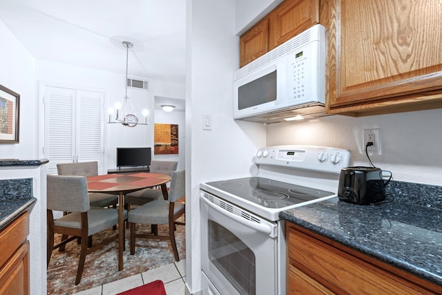 kitchen featuring visible vents, brown cabinetry, white appliances, light tile patterned floors, and a notable chandelier