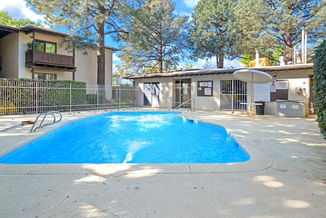 pool with a patio and fence