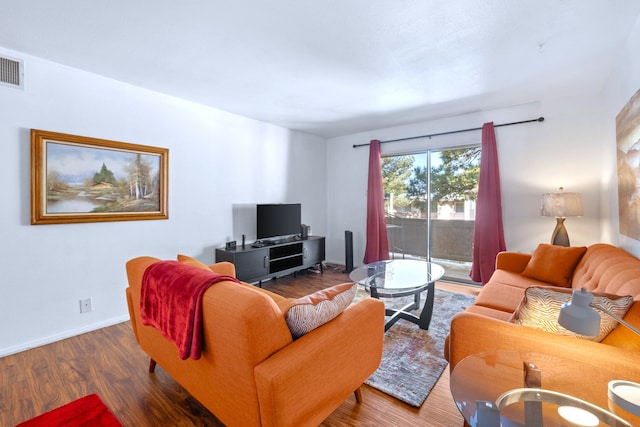 living area with baseboards and wood finished floors