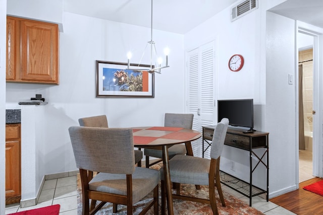 dining area with visible vents, baseboards, light tile patterned flooring, and an inviting chandelier