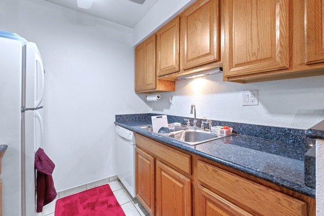 kitchen featuring white appliances, baseboards, ceiling fan, a sink, and light tile patterned floors
