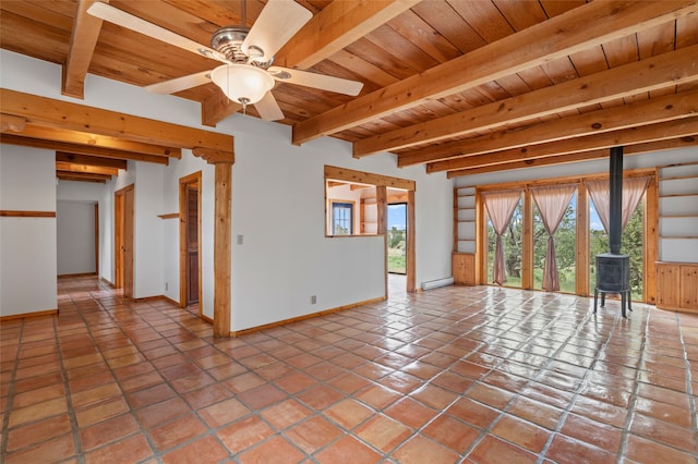 1 Jornada Loop, Santa Fe, NM 87508 - unfurnished living room featuring a wood stove, wooden ceiling with exposed beams, baseboards, baseboard heating, and a ceiling fan