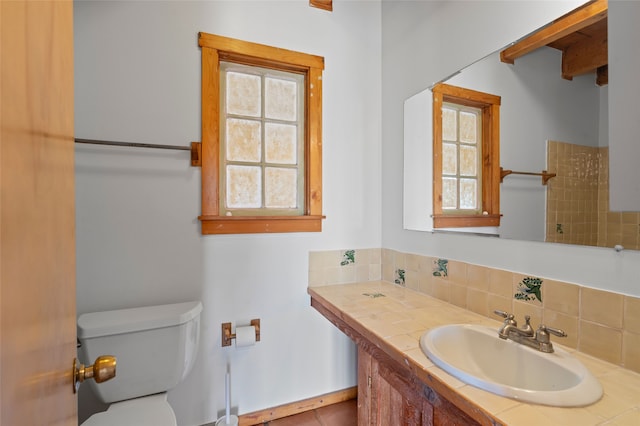 1 Jornada Loop, Santa Fe, NM 87508 - bathroom with toilet, vanity, and decorative backsplash