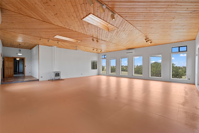 1 Jornada Loop, Santa Fe, NM 87508 - unfurnished living room featuring rail lighting, wood ceiling, a wood stove, a wall mounted AC, and vaulted ceiling