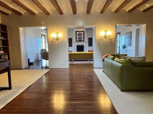 living room with beamed ceiling, wood finished floors, and a fireplace
