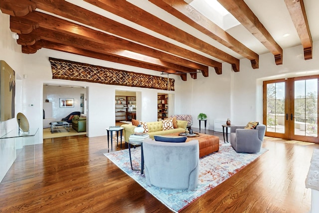 living room featuring built in features, french doors, beam ceiling, and wood finished floors