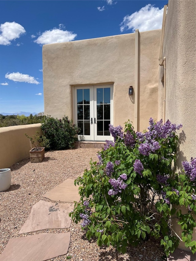 entrance to property featuring french doors and stucco siding