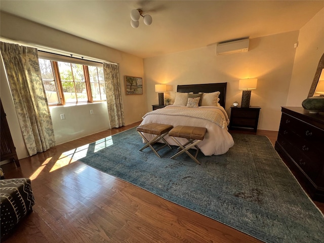 bedroom featuring a wall unit AC and wood finished floors