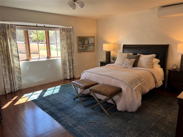 bedroom with an AC wall unit and wood finished floors