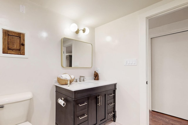 bathroom featuring vanity, wood finished floors, and toilet