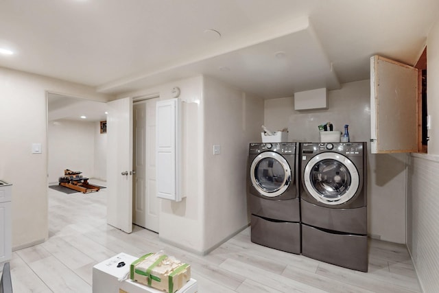 clothes washing area featuring laundry area, light wood-style flooring, and washer and dryer