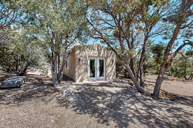 exterior space with french doors and stucco siding