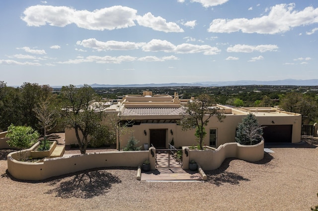 view of front of house with a garage, a mountain view, and stucco siding