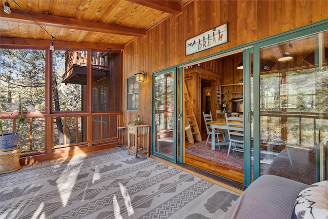 sunroom with a healthy amount of sunlight and beamed ceiling