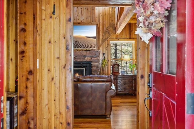 interior space featuring wooden walls, a fireplace, and wood finished floors