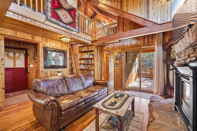 living room featuring wood-type flooring, wood walls, and a towering ceiling