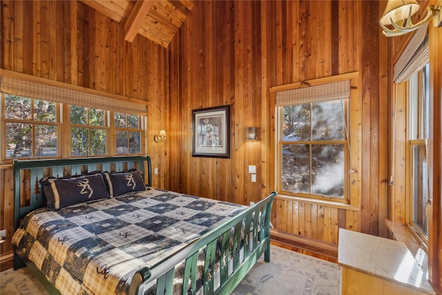 bedroom featuring wooden walls, vaulted ceiling with beams, and wood finished floors