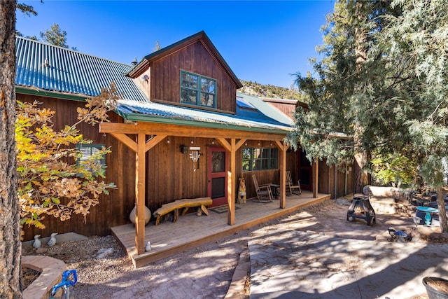 exterior space with a wooden deck and metal roof