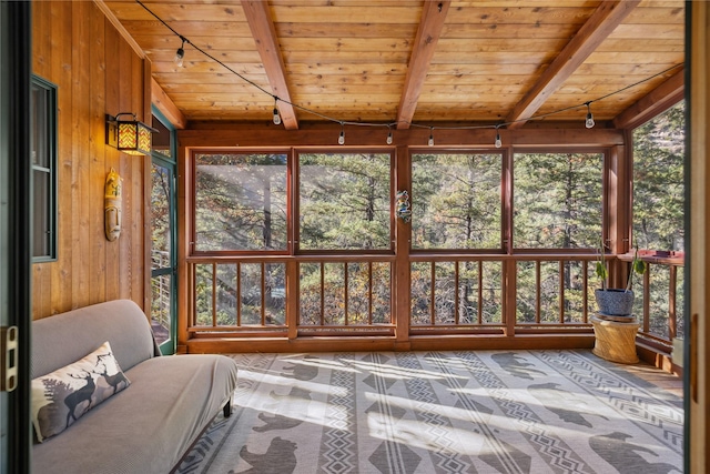 sunroom featuring track lighting, wood ceiling, lofted ceiling with beams, and wood walls