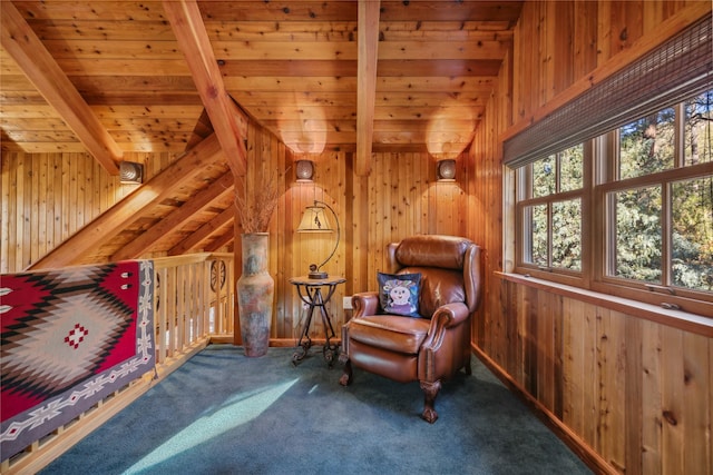 sitting room featuring wood walls, beam ceiling, and wooden ceiling