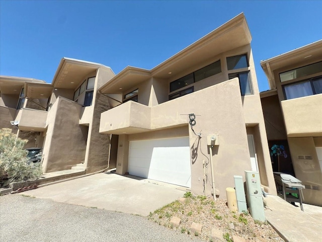 4621 Esperanza, Los Alamos, NM 87544 - view of front of property with a garage, stucco siding, concrete driveway, and a balcony