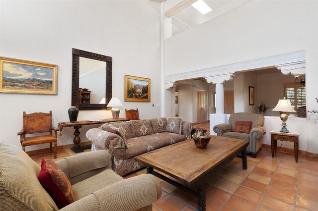 3101 Old Pecos Trl Unit 627, Santa Fe, NM 87505 - living room featuring light tile patterned floors, ornate columns, high vaulted ceiling, baseboards, and beamed ceiling