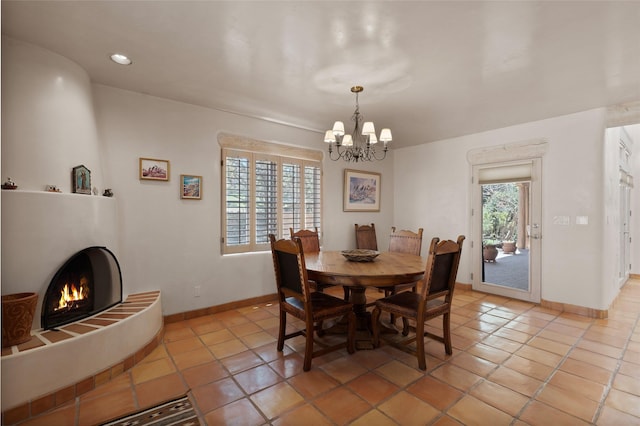 3101 Old Pecos Trl Unit 627, Santa Fe, NM 87505 - dining space featuring light tile patterned floors, a notable chandelier, a tile fireplace, and baseboards