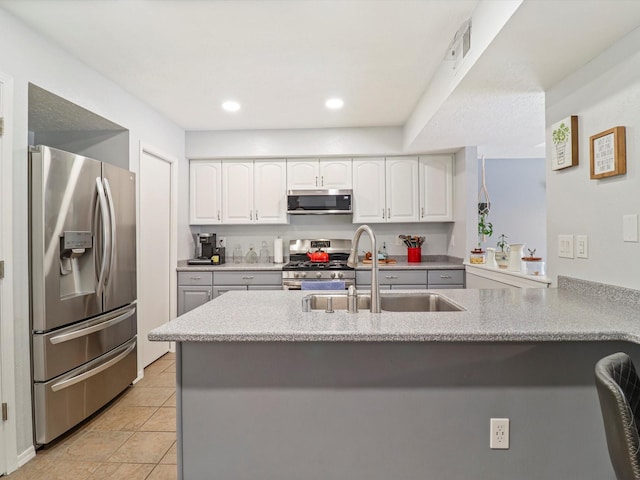 505 Oppenheimer Dr Unit 1304, Los Alamos, NM 87544 - kitchen with visible vents, a peninsula, white cabinets, a sink, and stainless steel appliances