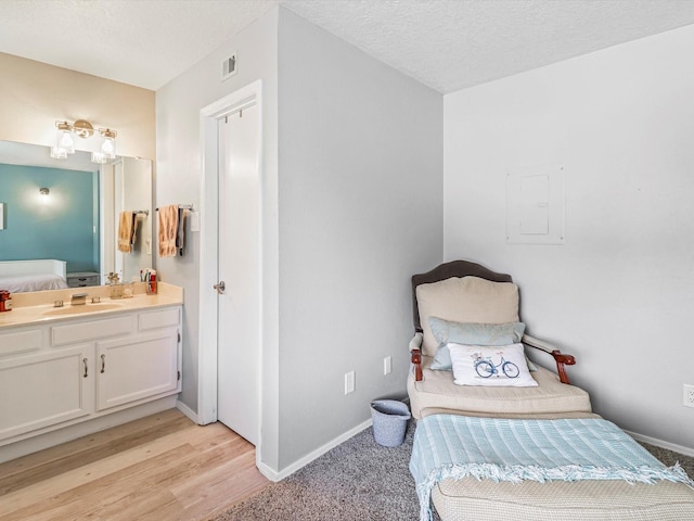 505 Oppenheimer Dr Unit 1304, Los Alamos, NM 87544 - bedroom with visible vents, a sink, baseboards, connected bathroom, and light wood-style floors