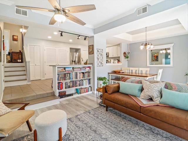 505 Oppenheimer Dr Unit 1304, Los Alamos, NM 87544 - living area featuring visible vents, stairs, ceiling fan with notable chandelier, and light wood-type flooring