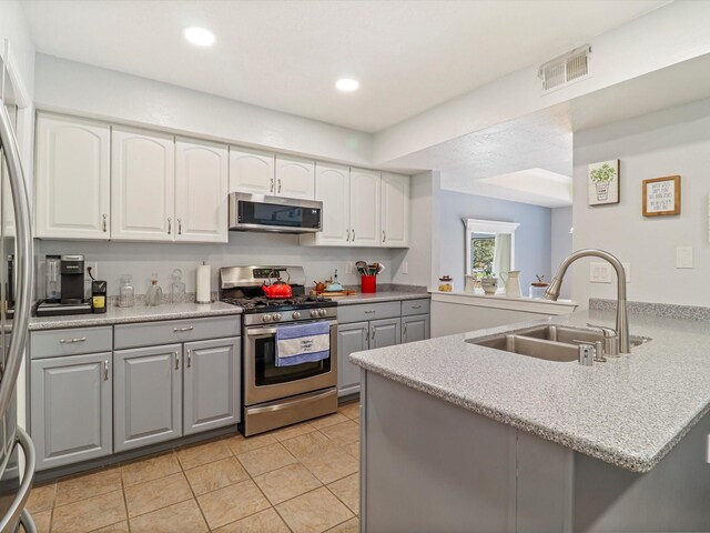 505 Oppenheimer Dr Unit 1304, Los Alamos, NM 87544 - kitchen with visible vents, a peninsula, gray cabinets, a sink, and appliances with stainless steel finishes