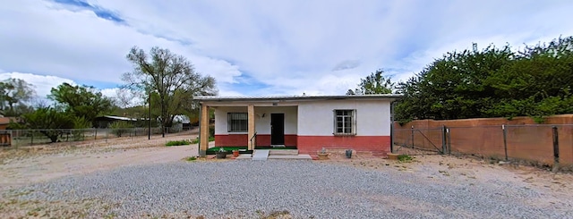 view of front of home with stucco siding and fence