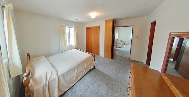 carpeted bedroom featuring a closet and visible vents