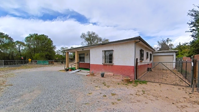 manufactured / mobile home with fence, stucco siding, a garage, and brick siding