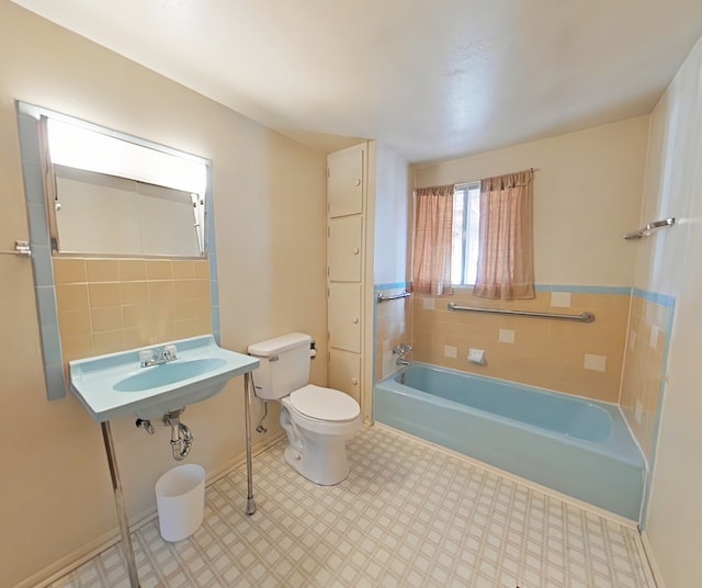 full bathroom featuring baseboards, a tub, toilet, and tile patterned floors