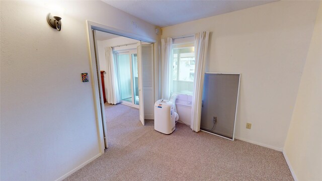 empty room with baseboards and light carpet