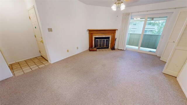 unfurnished living room with tile patterned floors, a tiled fireplace, carpet, a ceiling fan, and baseboards