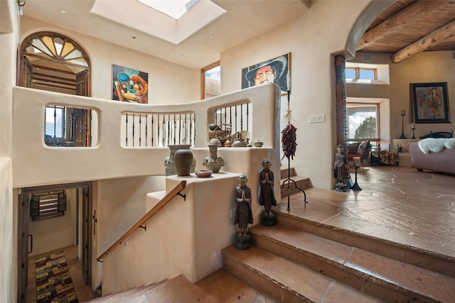 35 Sage Cir, Santa Fe, NM 87506 - stairs with a skylight, beam ceiling, and a towering ceiling