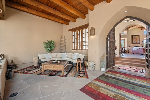35 Sage Cir, Santa Fe, NM 87506 - tiled living room featuring a healthy amount of sunlight, arched walkways, beamed ceiling, and wood ceiling