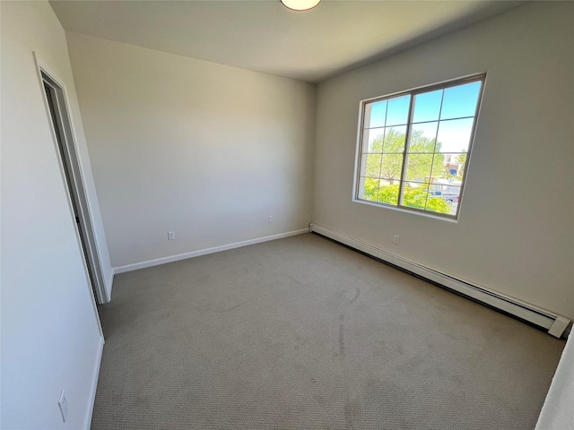 empty room featuring baseboards, baseboard heating, and carpet