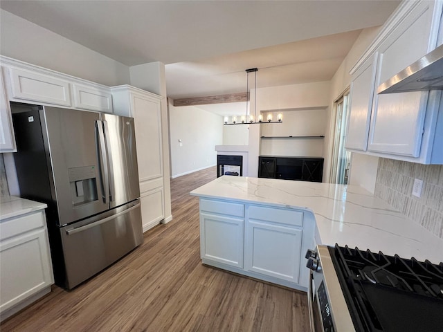 kitchen with light wood-style floors, stainless steel appliances, open floor plan, white cabinetry, and a peninsula