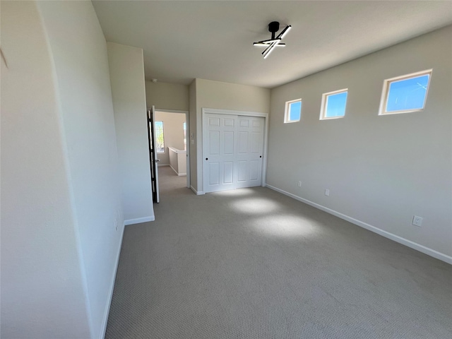 unfurnished bedroom with baseboards, carpet flooring, and a closet