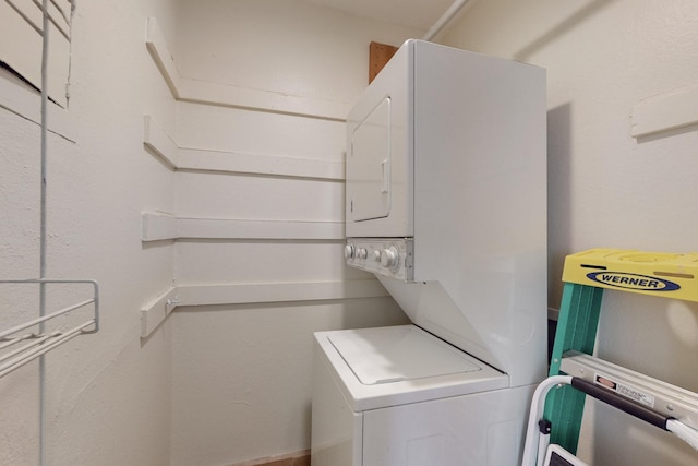 clothes washing area featuring laundry area and stacked washer and clothes dryer