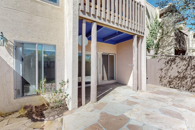 view of patio featuring fence and a balcony
