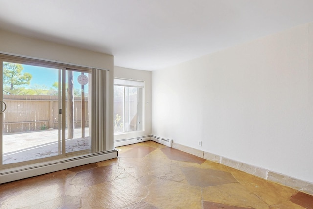 spare room with baseboards, a baseboard radiator, and stone tile flooring
