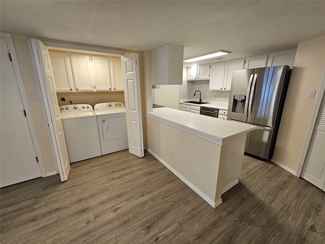 kitchen with washing machine and clothes dryer, stainless steel fridge, a sink, dishwasher, and dark wood-style floors