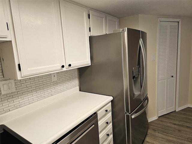 kitchen featuring appliances with stainless steel finishes, light countertops, white cabinetry, decorative backsplash, and dark wood-type flooring