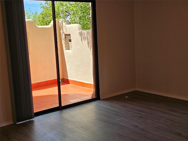 doorway featuring baseboards and wood finished floors