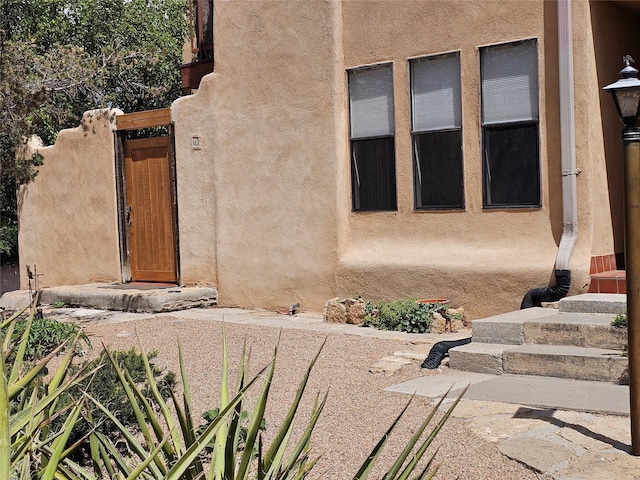 entrance to property featuring a gate and stucco siding