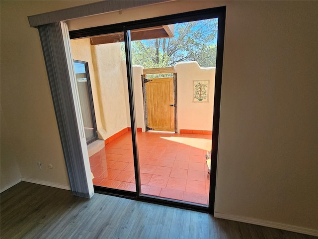 entryway with baseboards and wood finished floors